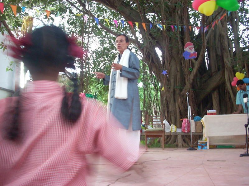 Photographer:Andrea | Domique conducting the choir under the Banyam tree