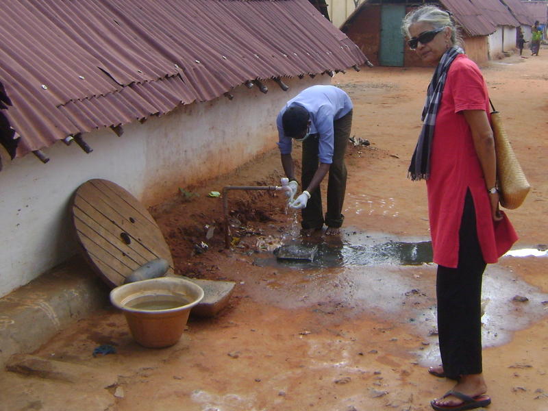 Photographer:Herman | Sham cleaning the sludge of his hands with Renu standing by.
